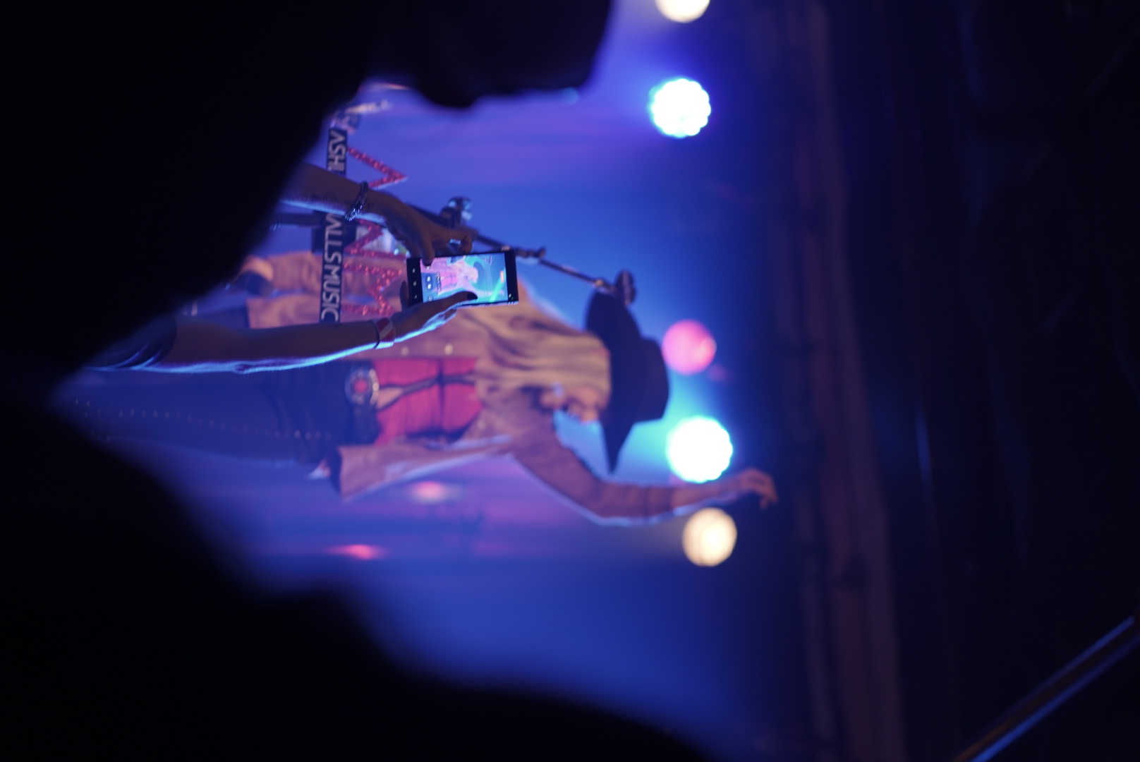 Performer onstage under blue and purple light