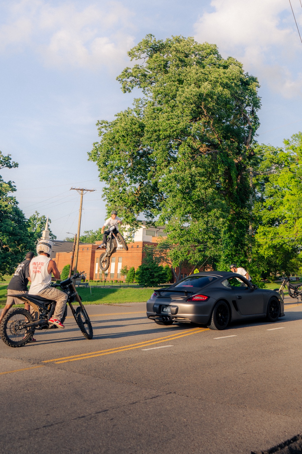 Motorcycle rider doing a wheelie on a city street