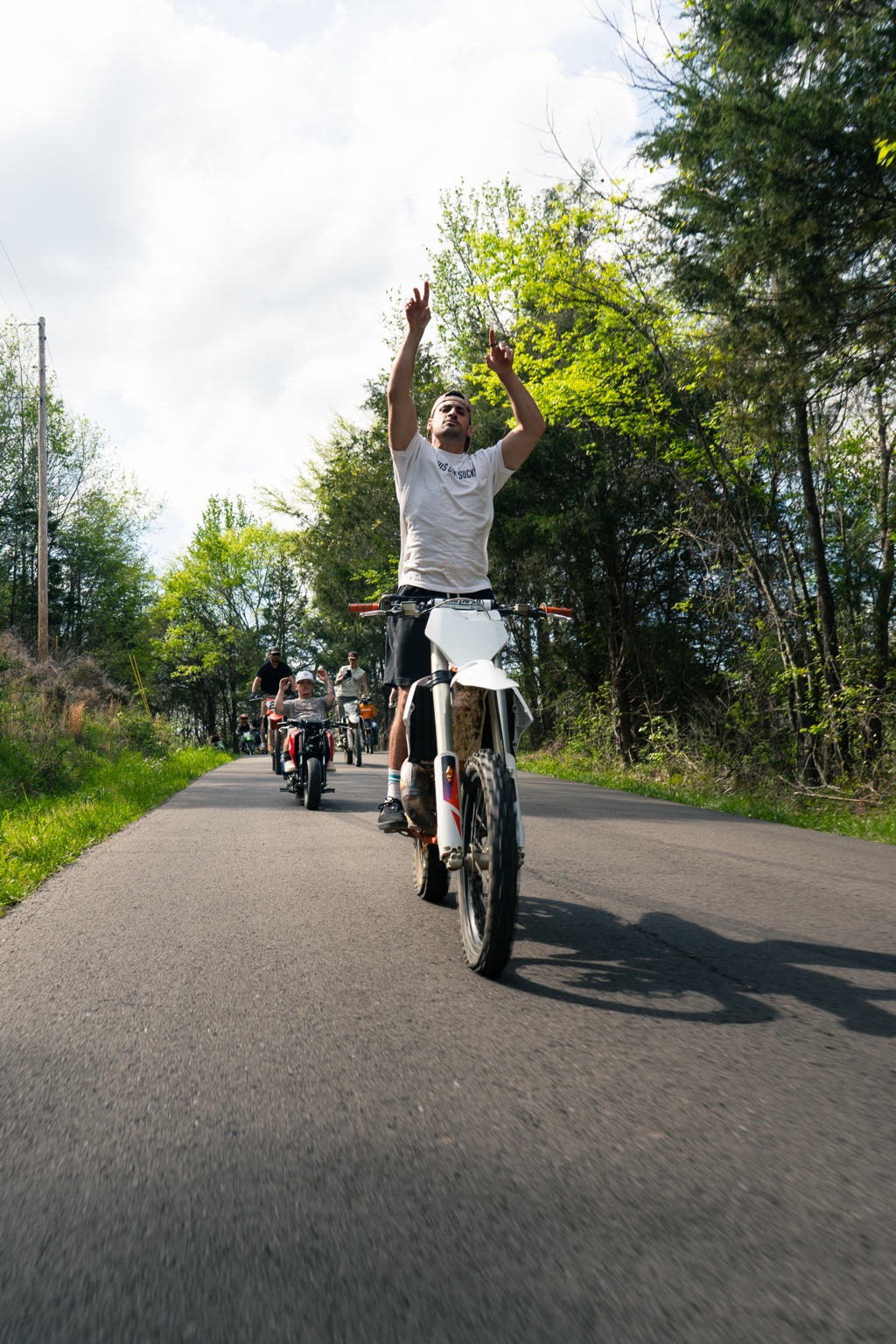 Motorcycle rider doing a wheelie with a group