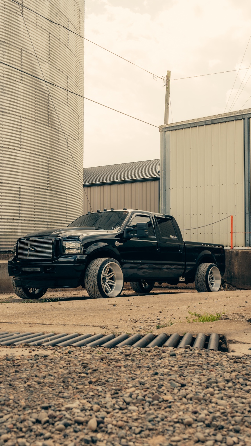 Black diesel truck beside an industrial building